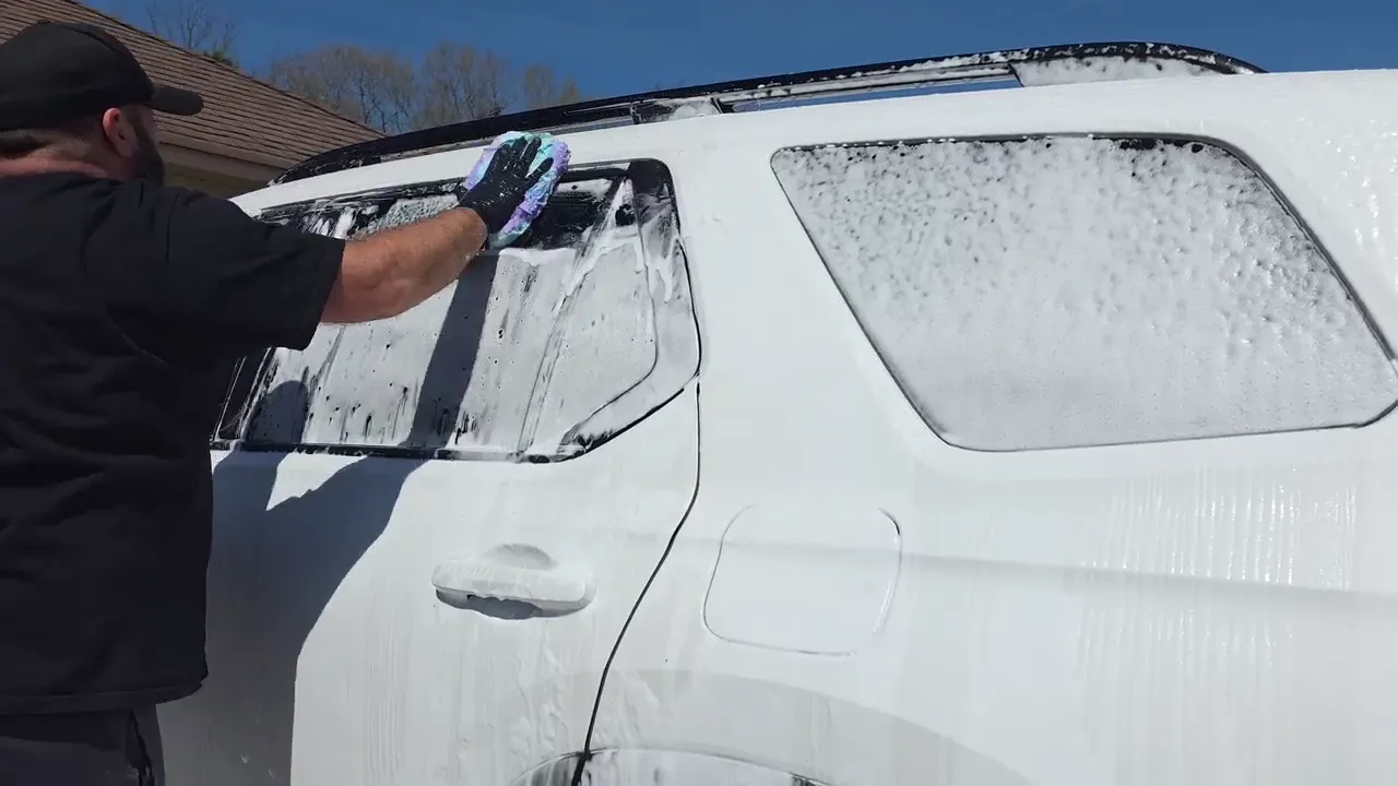 A white SUV being hand washed by DownHome Detail